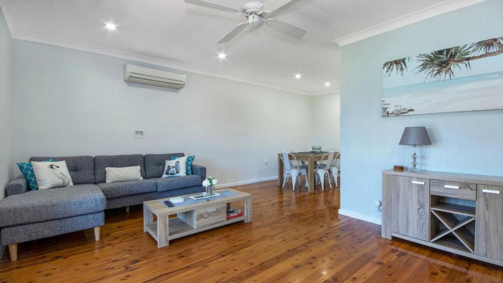 a living room with a couch and a table at Edendale Family Fun - Ettalong Beach in Ettalong Beach