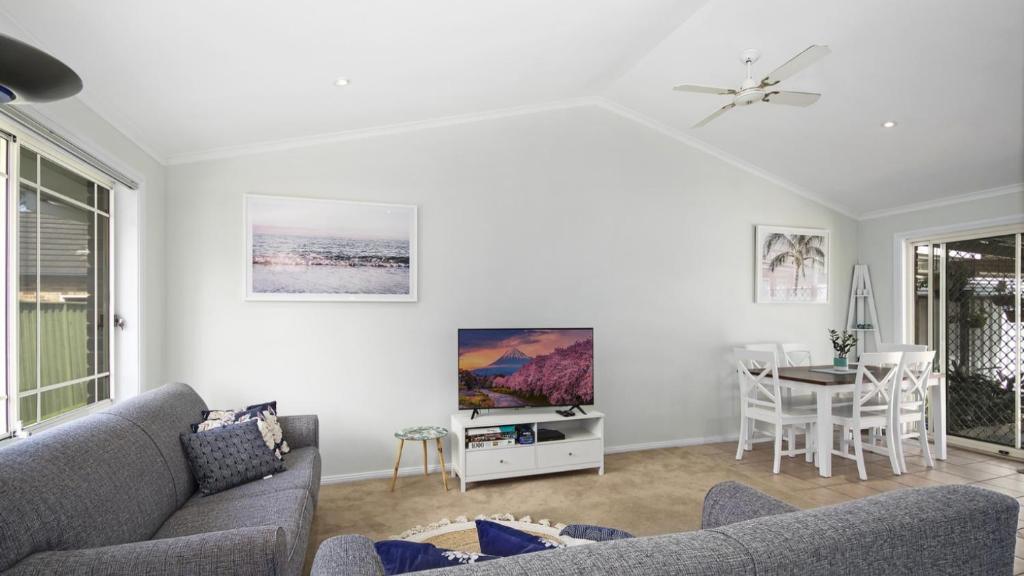 a living room with a couch and a table at Beach Daze - Umina Beach Family Friendly in Umina