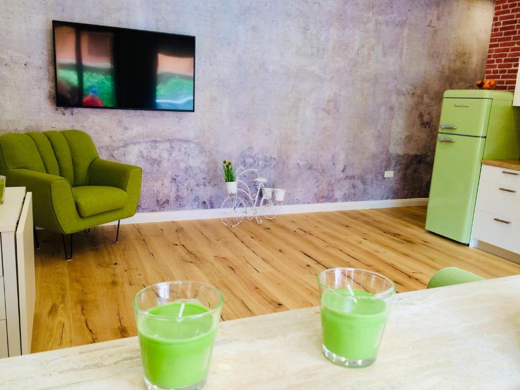 two glasses of green liquid sitting on a table at Dalomar Apartment in Biograd na Moru