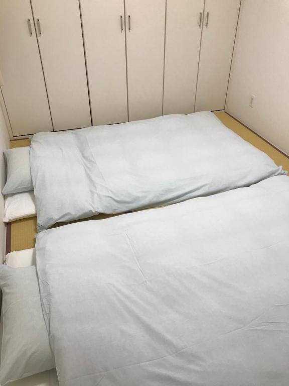 Postel nebo postele na pokoji v ubytování Across Omoromachi Naha