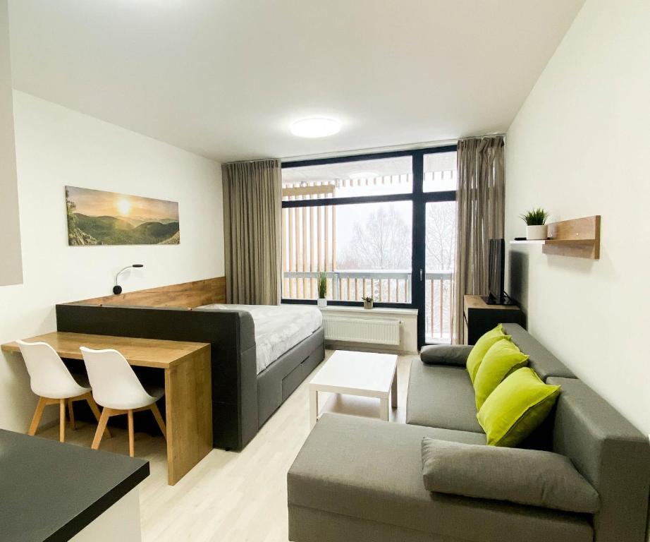 Zimmer mit einem Bett, einem Sofa und einem Tisch in der Unterkunft Apartmán LUMI Zadov in Stachy