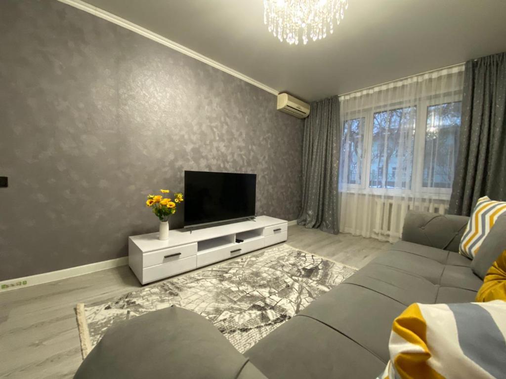 a living room with a couch and a flat screen tv at Квартира на Тулебаева in Almaty