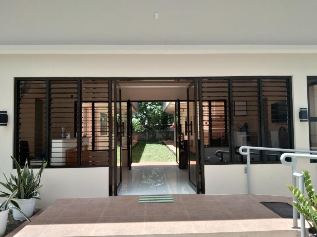 an open entrance to a house with wooden doors at Claytown Pension House in Dumaguete