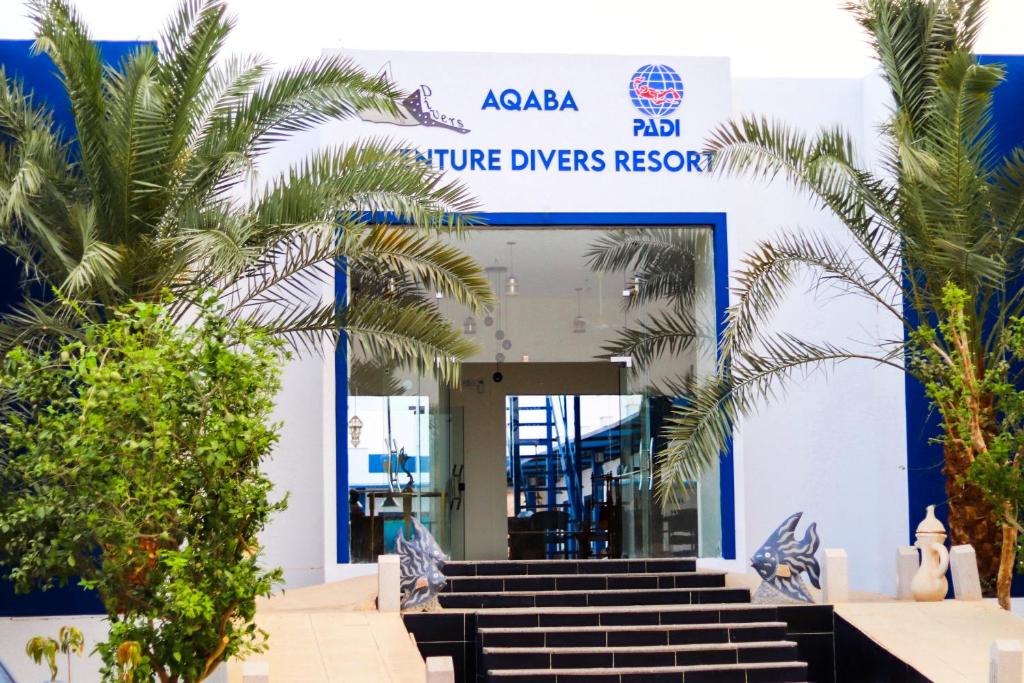 een blauw-wit gebouw met trappen en palmbomen bij Aqaba Adventure Divers Resort & Dive Center in Aqaba