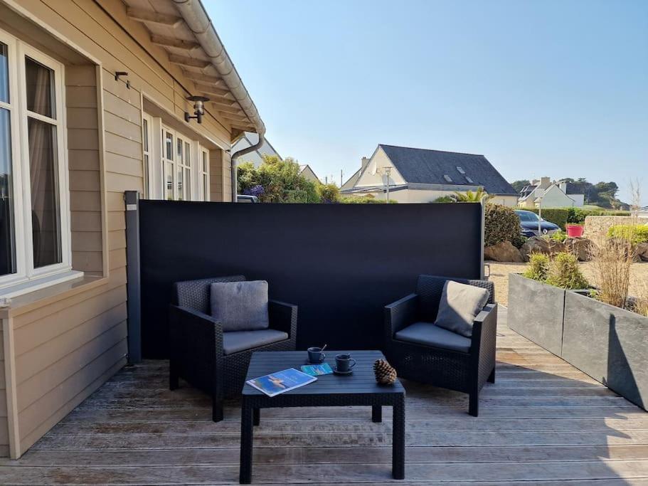 a patio with two chairs and a coffee table at Le Château de Sable in Plougasnou