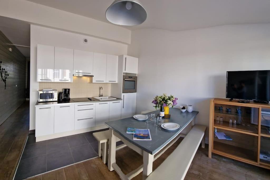 a kitchen with a table with two plates on it at Le Château de Sable in Plougasnou