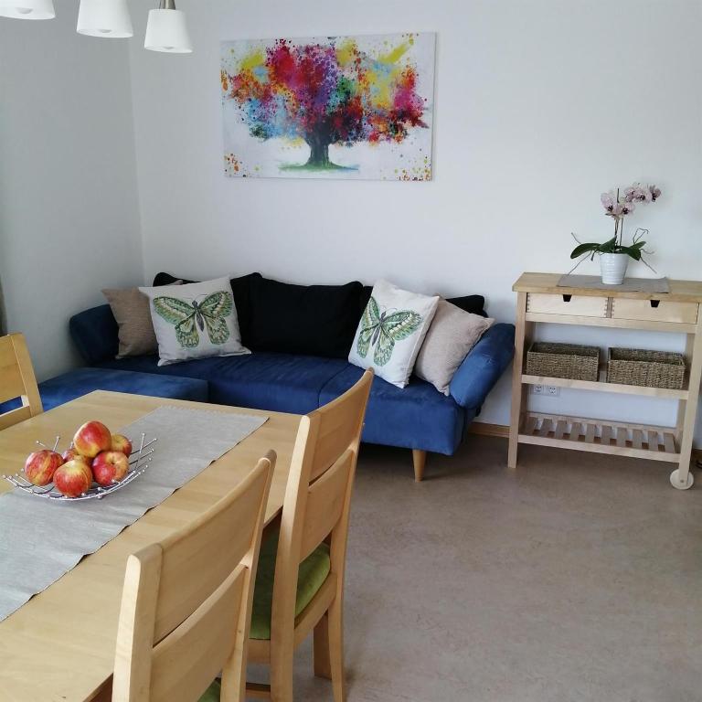 a living room with a blue couch and a table at Ferienwohnung Zammernig in Ferndorf