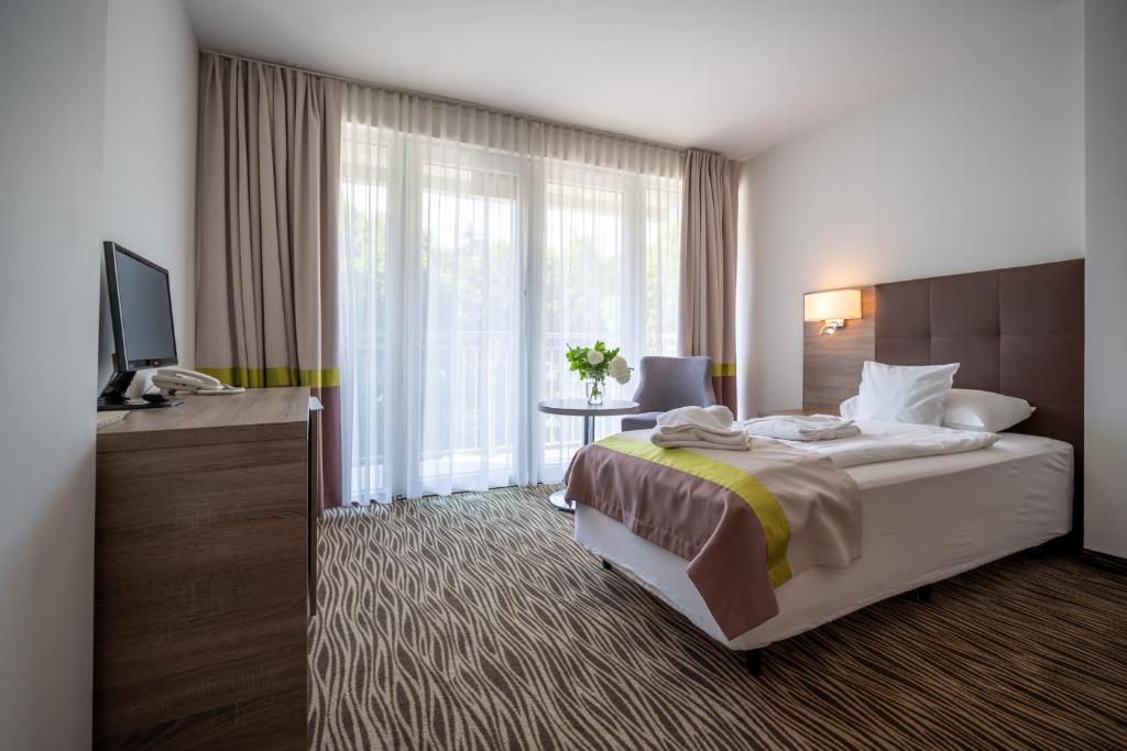 um quarto de hotel com uma cama e uma televisão em Perła Bałtyku em Świnoujście