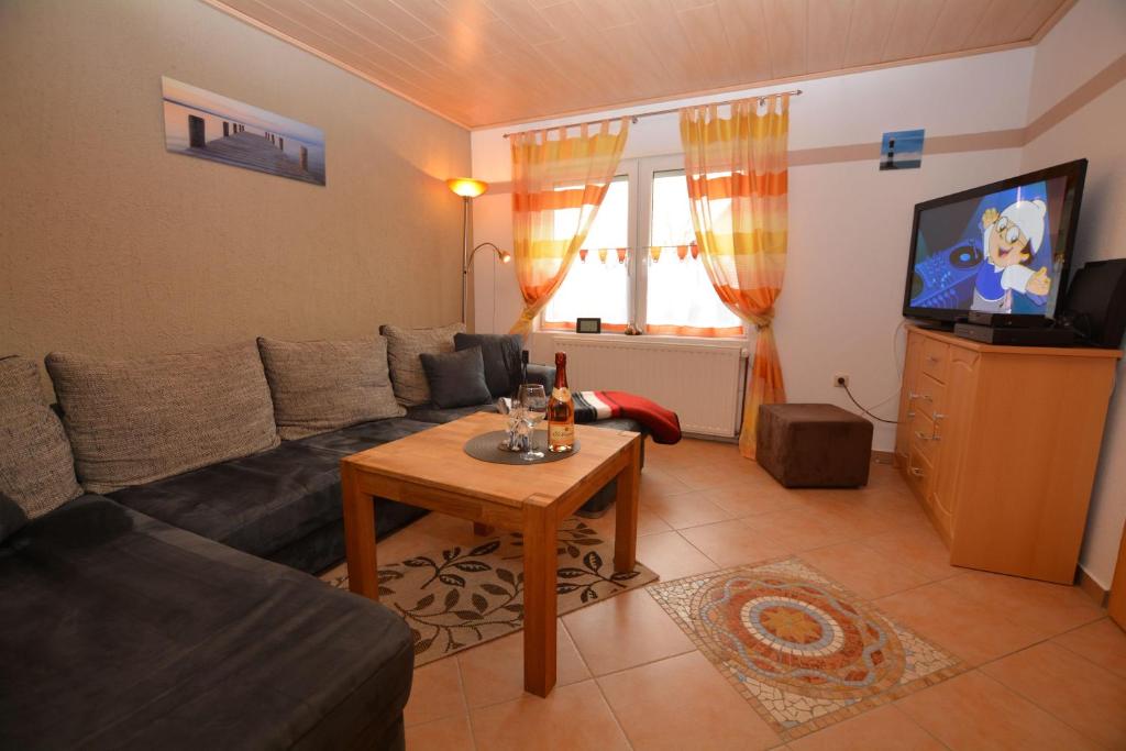 ein Wohnzimmer mit einem Sofa und einem Tisch in der Unterkunft Haus Karin Ferienwohnung 3 in Büsum