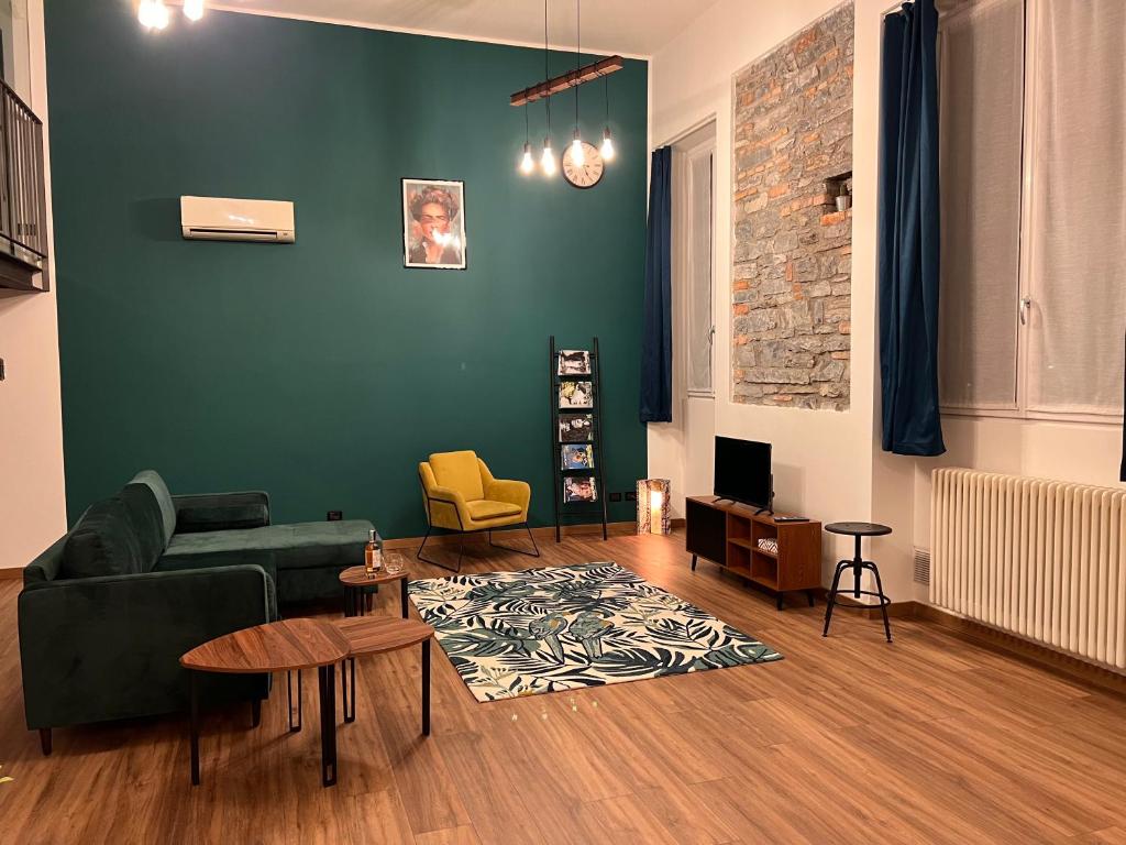 - un salon avec un canapé et un mur vert dans l'établissement OpenSpaceMonti82 a pochi passi dal Duomo di Como, à Côme