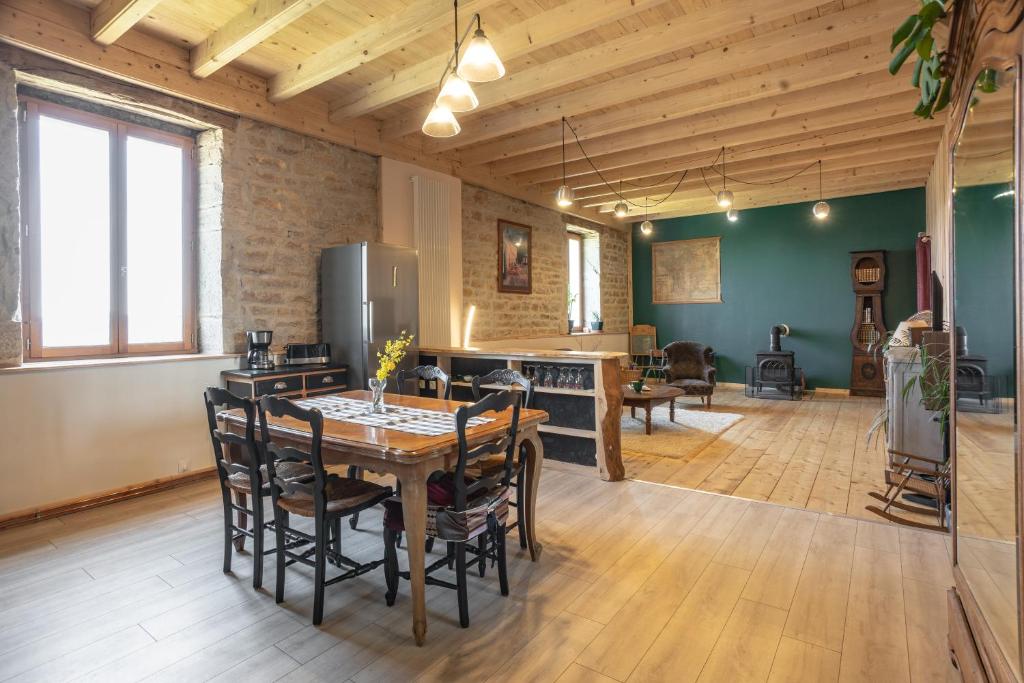 cocina y comedor con mesa y sillas en Appartement de charme dans une maison isolée, en Présilly