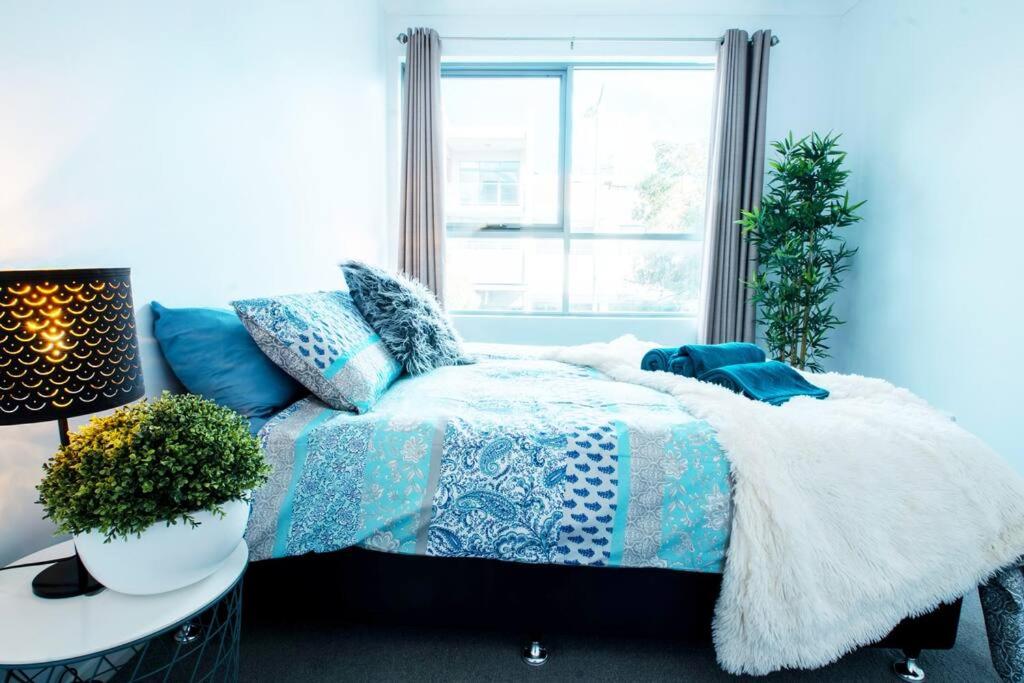 a blue bedroom with a bed and a window at 100 Walk Score Unlimited Wifi Netflix Immaculate in Perth