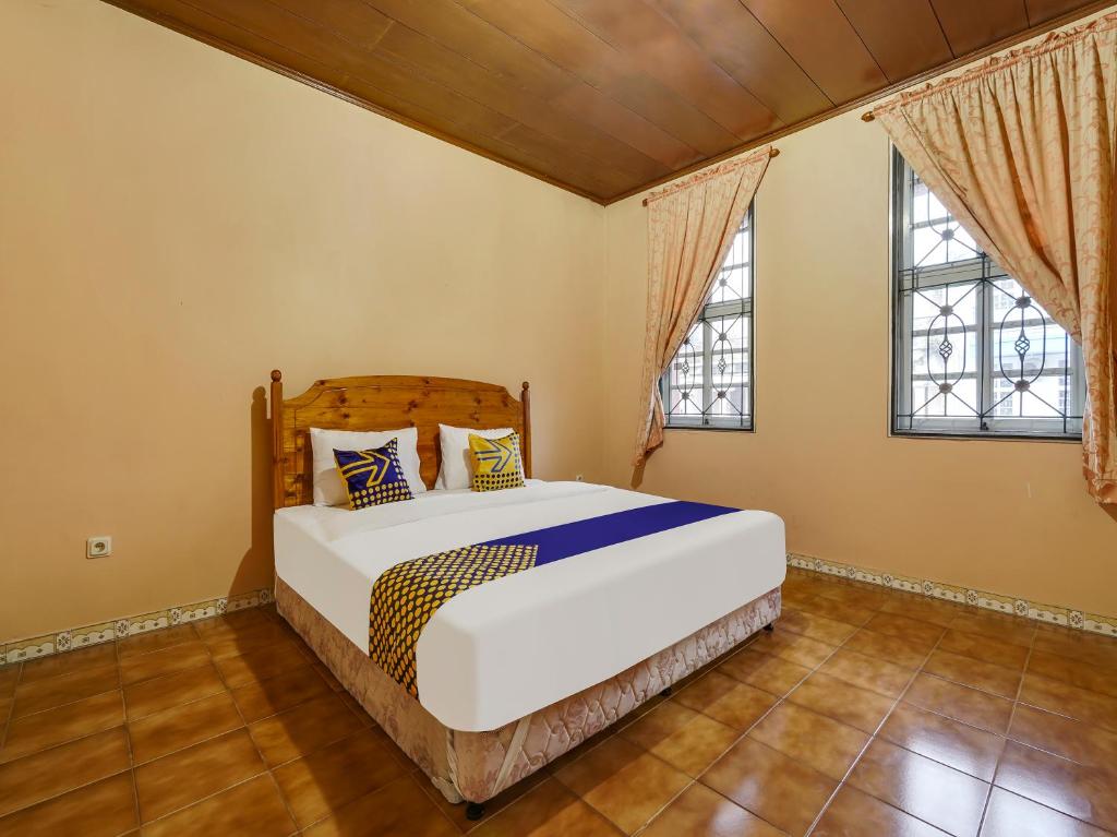 een slaapkamer met een bed en 2 ramen bij SPOT ON 91107 Villa Galaxy Resort in Cikundul