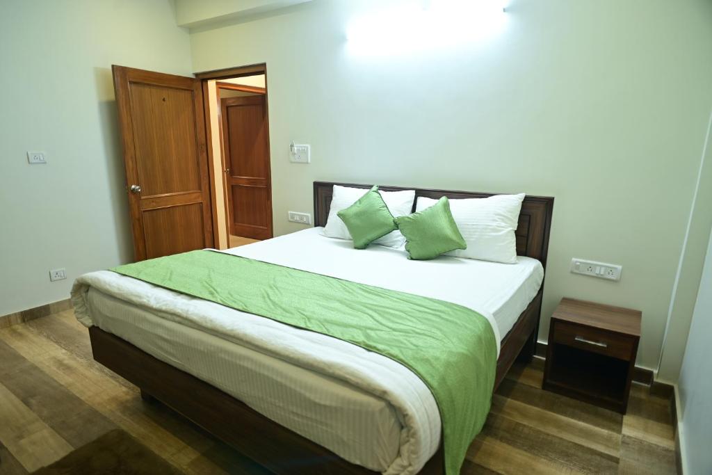 a bedroom with a large bed with green sheets and pillows at The Fern Villas Nainital By Beyond Stay in Nainital