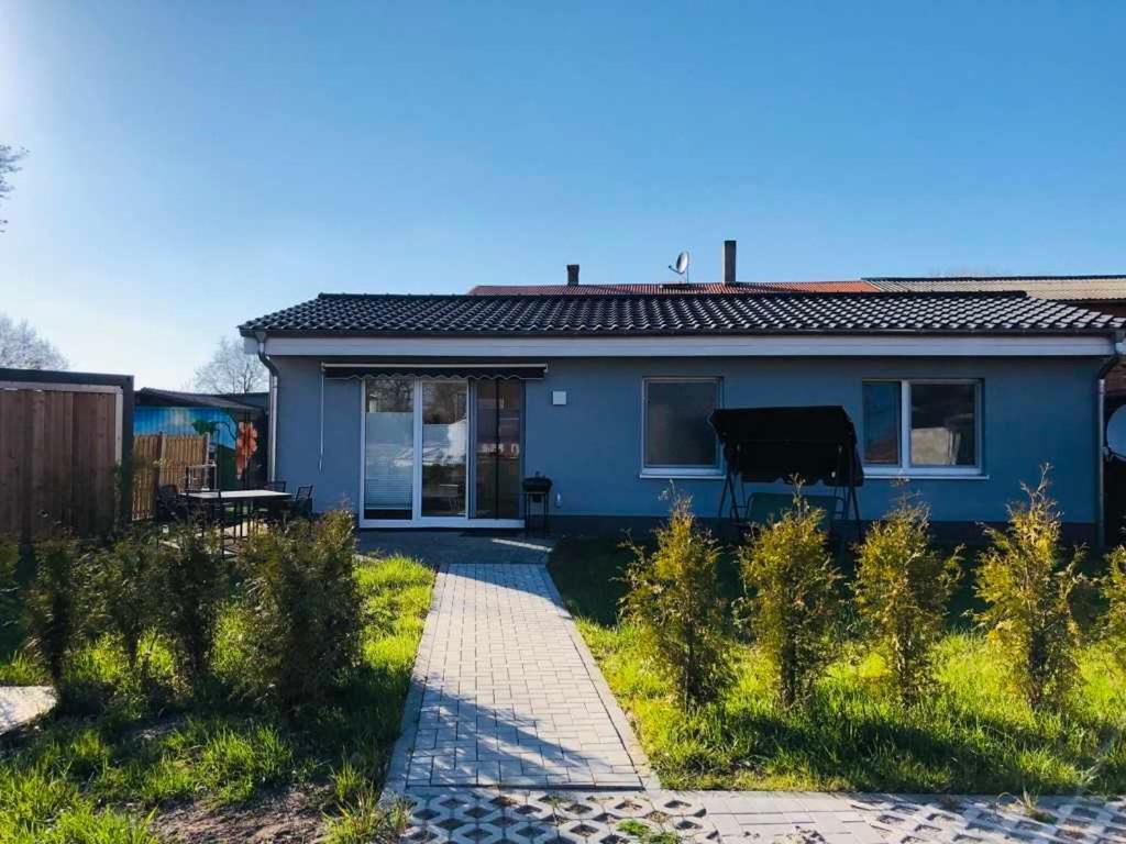 a blue house with a piano in a yard at Ferienhäuschen Seenrunde 