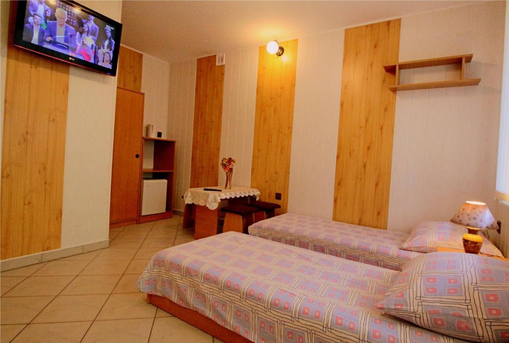 a hotel room with two beds and a flat screen tv at Pokoje Ewa in Ostrowo