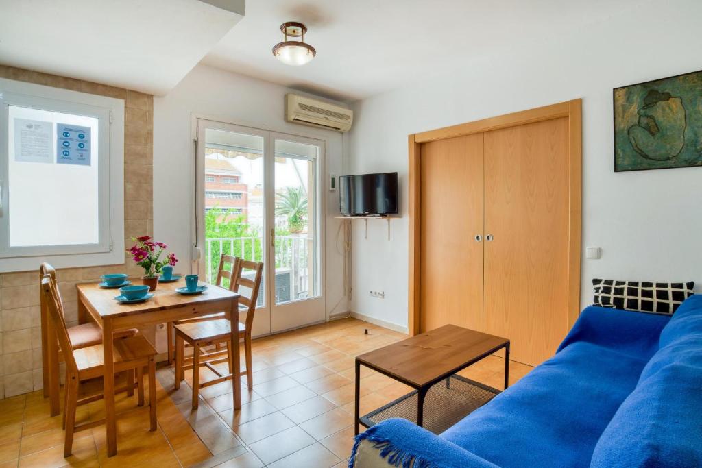 a living room with a blue couch and a table at Apartament Luisa in Lloret de Mar