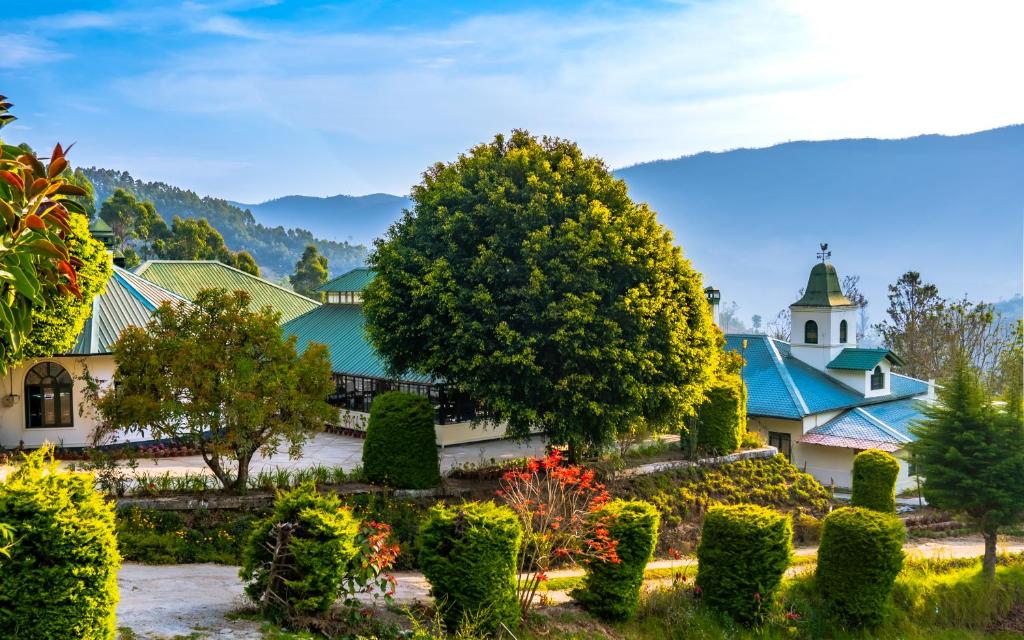 a garden in front of a building with a tower at Southern Panorama Campnoel Munnar in Vattavada
