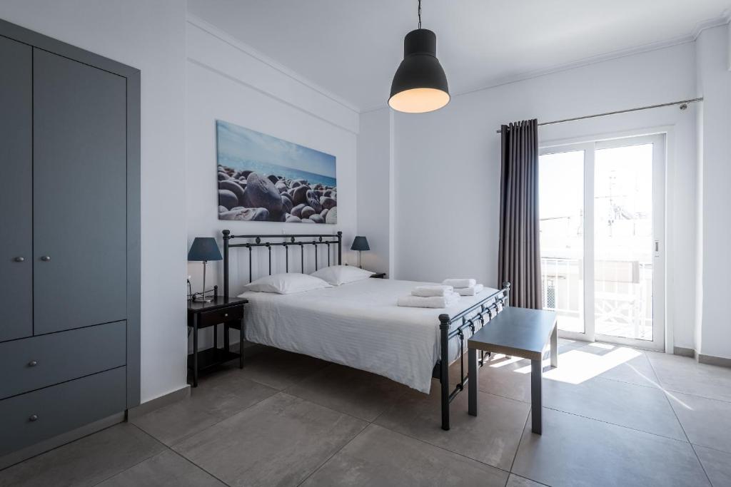 een slaapkamer met een bed, een tafel en een stoel bij Milva Apartments in Kos-stad