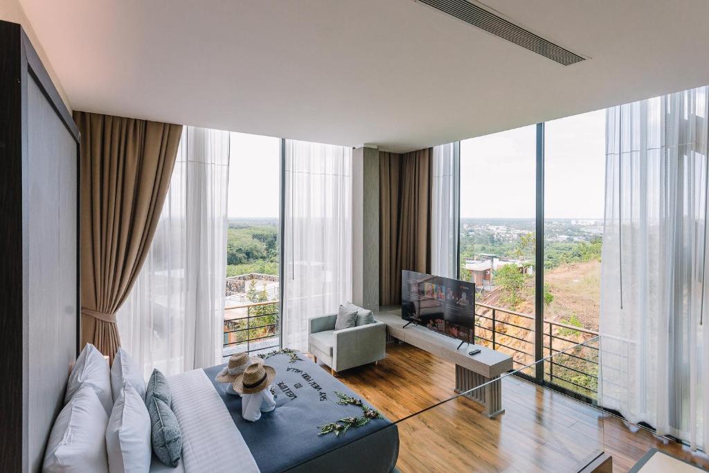 een woonkamer met een bank en een tv bij Sky View Luxury Pool Villa - SHA in Suratthani