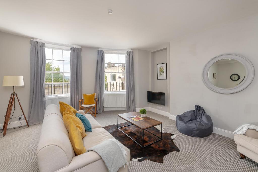 a living room with a white couch and a table at Georgian 2 Bed Apartment with 3 Bathrooms and Parking in Bath