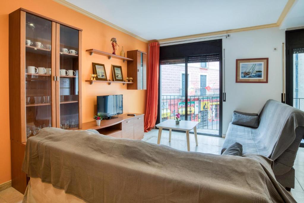 a living room with a couch and a tv at Apartament Yaco 2 in Lloret de Mar