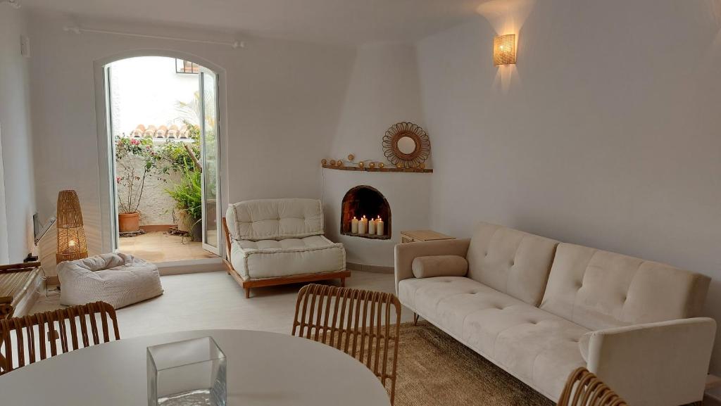 salon z kanapą i kominkiem w obiekcie New Boho Home with Balcony, Private Garden and Communal Pool w mieście Nerja