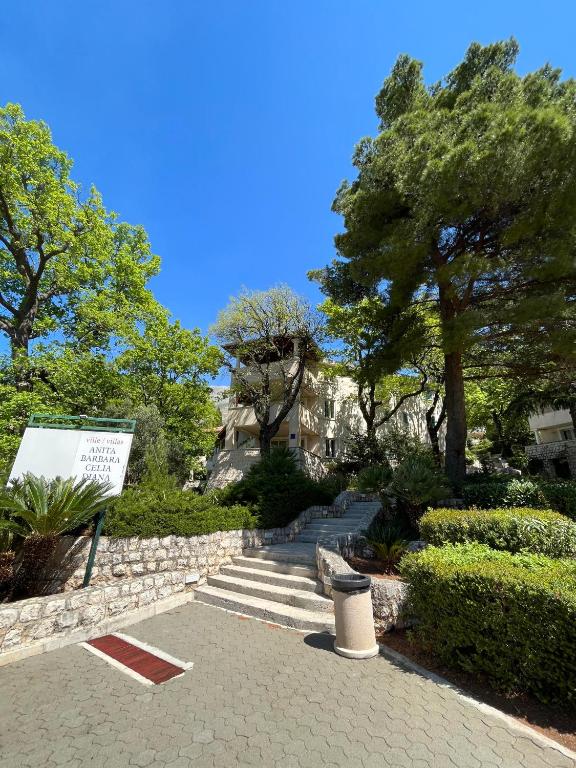 a garden with stairs and trees and a building at Aparthotel Plat in Mlini