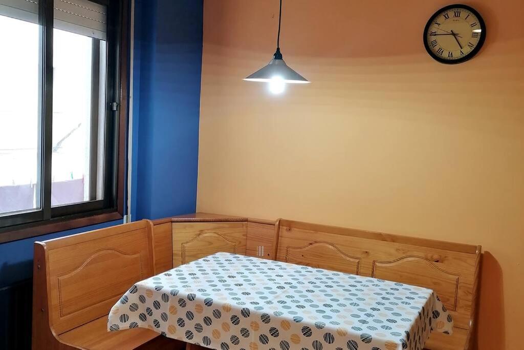 ein Schlafzimmer mit einem Bett und einer Uhr an der Wand in der Unterkunft Apartamento para 6 personas en Barbastro in Barbastro