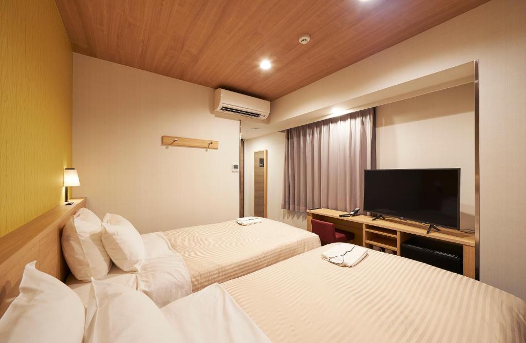 Postel nebo postele na pokoji v ubytování Sotetsu Fresa Inn Tokyo Tamachi