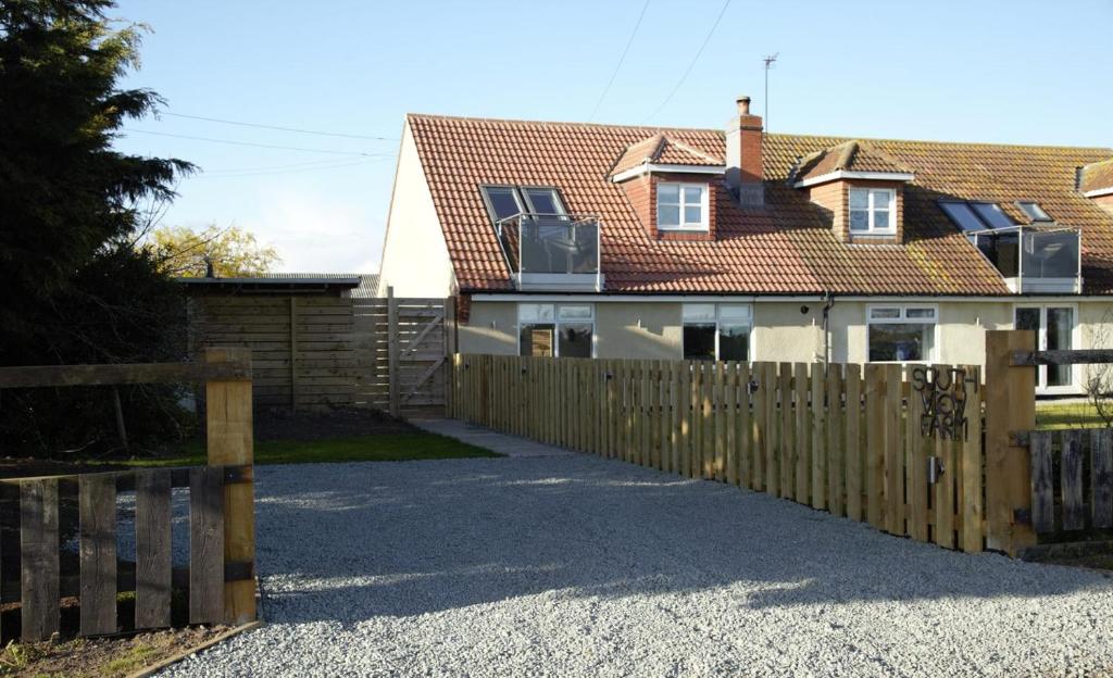 a wooden fence in front of a house at Southview farm in Halsham