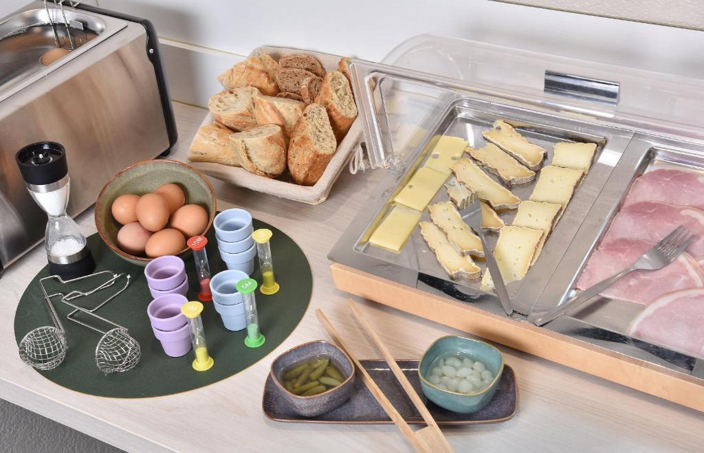 a table with a tray of food with eggs and bread at Contact Hôtel Astréa Nevers Nord et son restaurant la Nouvelle Table in Varennes Vauzelles