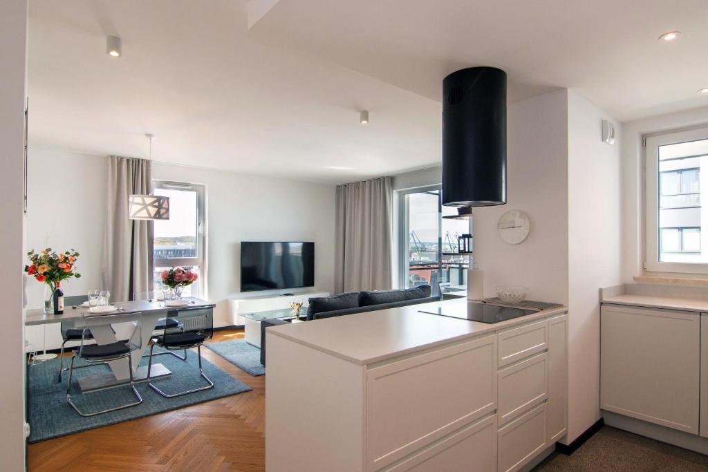 a kitchen and living room with a table and a couch at Maya's Flats & Resorts 46 - NEW PANORAMA VIEW Walowa Str in Gdańsk