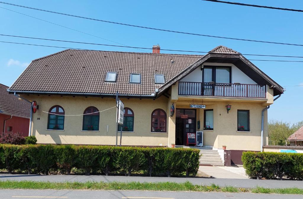 ein gelbes Haus mit braunem Dach in der Unterkunft Teke Panzió in Körmend