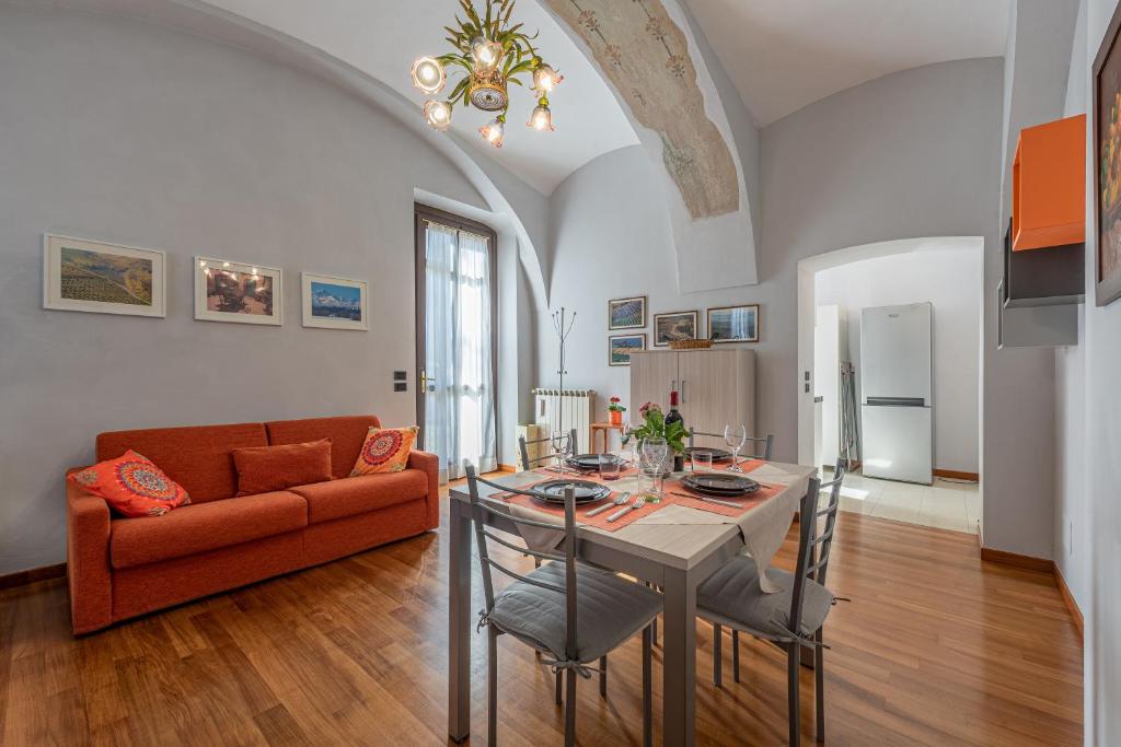een woonkamer met een tafel en een bank bij L'Antico Cedro Apartment in Alba