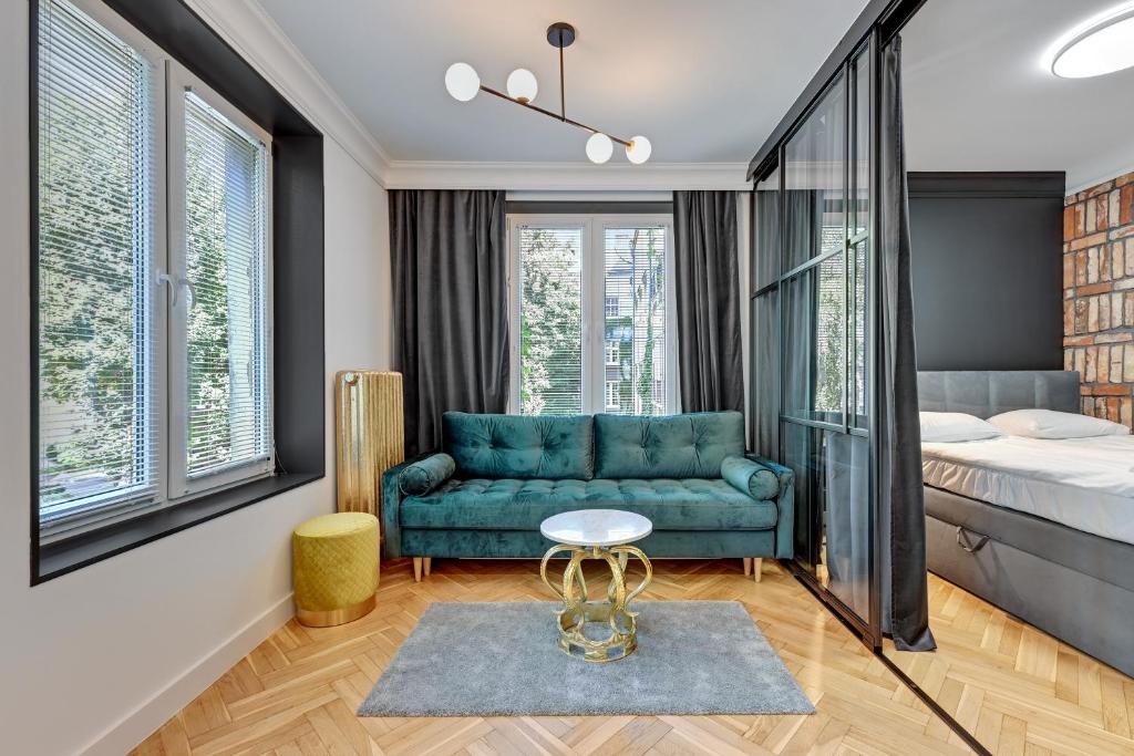 a bedroom with a blue couch and a bed at Downtown Apartments Old Town Grobla I in Gdańsk