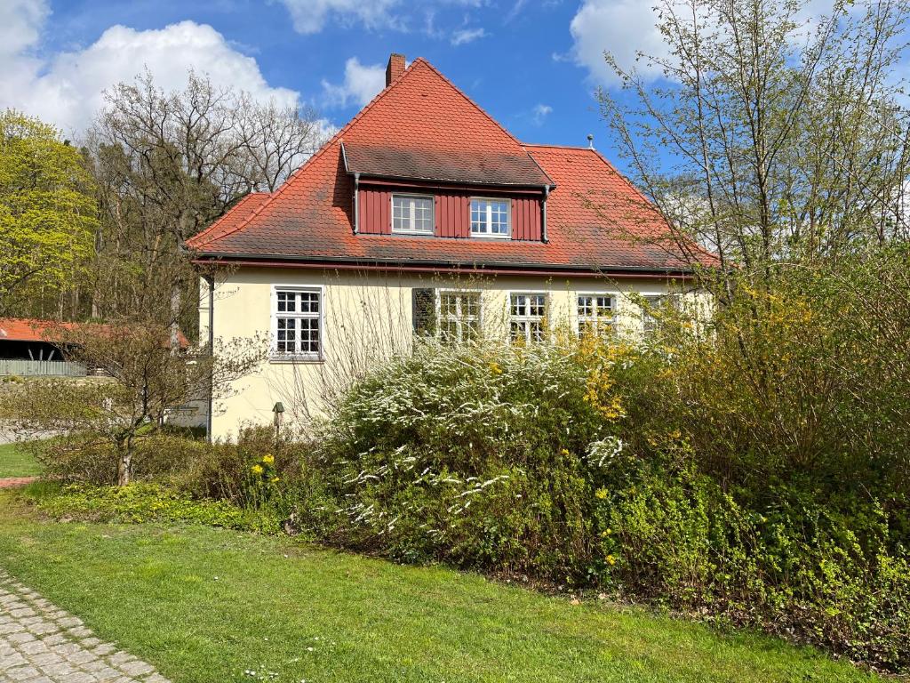 a small white house with a red roof at Gästezimmer in herrschaftlicher Villa in Krakow am See