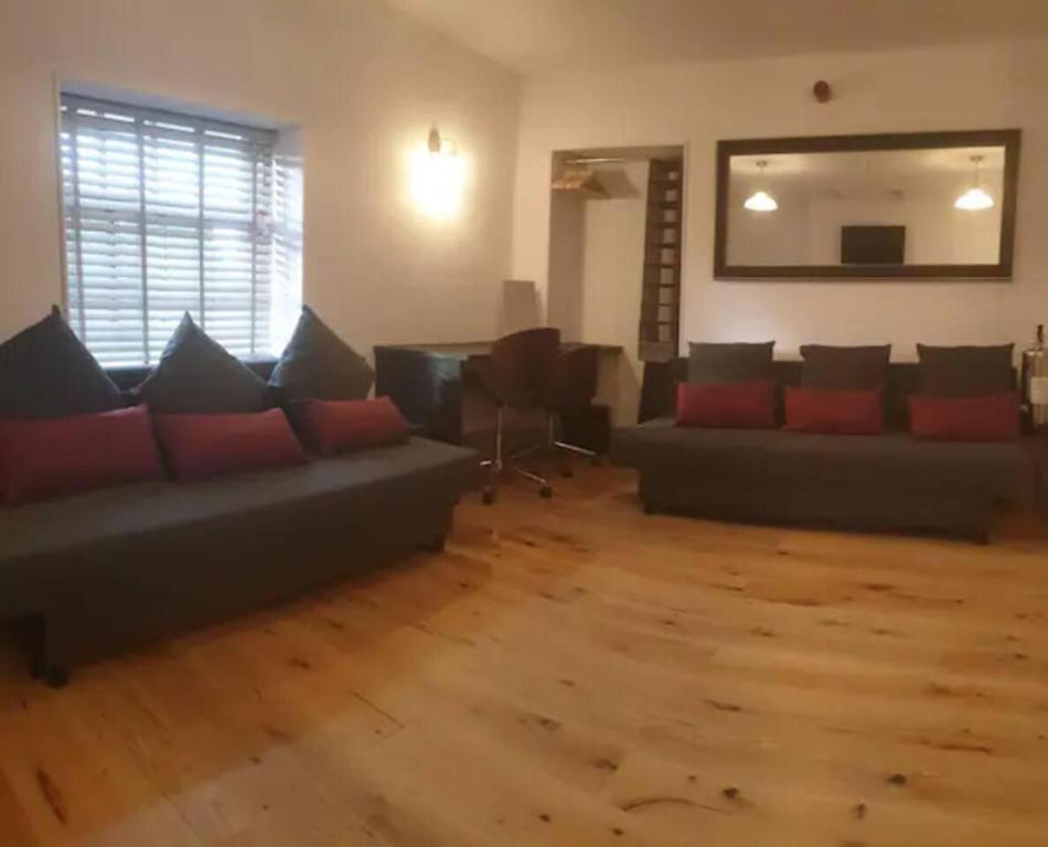 uma sala de estar com sofás e piso em madeira em Sparks - Family Suite in Canalside Guesthouse em Burnley