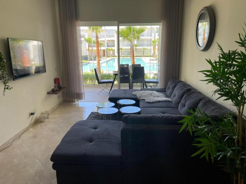 a living room with a blue couch and a table at Appartement vue piscine bien équipé et bien ensoleillé in Casablanca