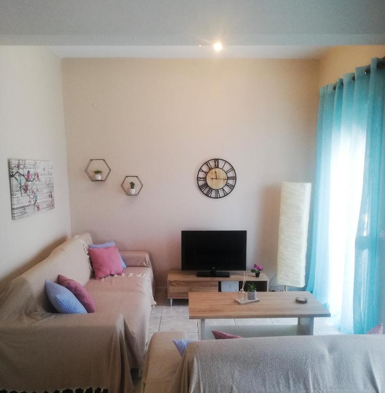 a living room with a couch and a tv at Iliada's apartment in Polychrono
