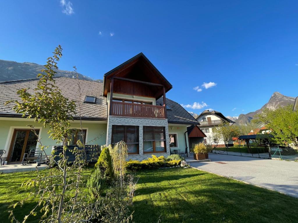 ein Haus mit Bergen im Hintergrund in der Unterkunft ISONZO APARTMENT in Bovec