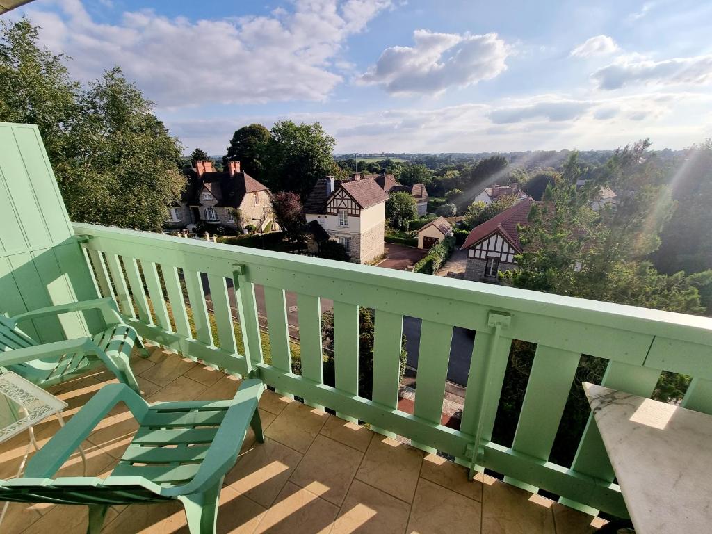 a balcony with a chair and a view of a town at Studio avec superbe vue 5min à pied des Thermes in Bagnoles de l'Orne