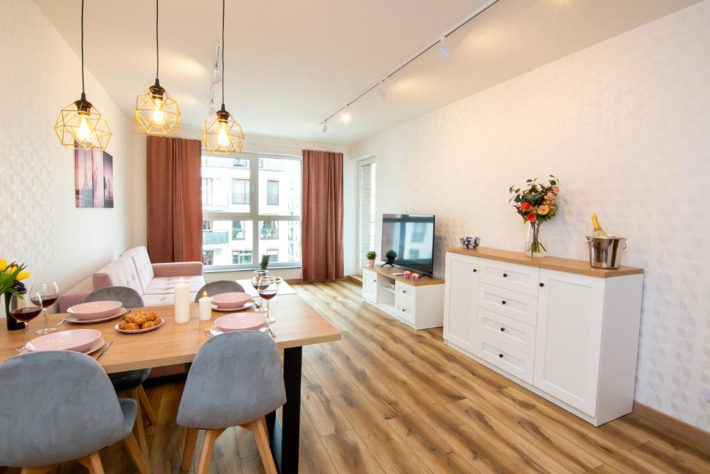 sala de estar con mesa de comedor y TV en Maya's Flats & Resorts 48 - Szafarnia, en Gdansk