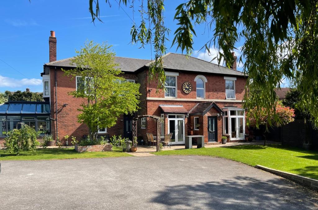 ein Backsteinhaus mit einer Einfahrt davor in der Unterkunft Borrowfield Lodge in Derby