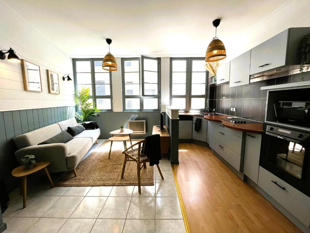 a living room with a couch and a table at L'Appart du Palais A 150m de la Grande Plage in Les Sables-dʼOlonne