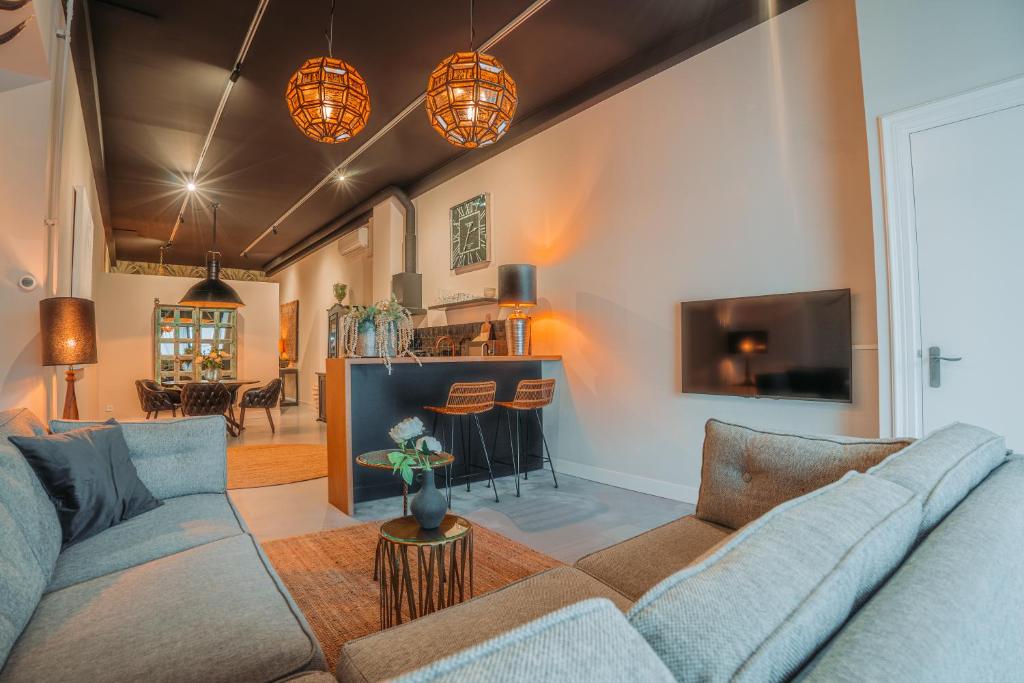 a living room with a couch and a tv at Short Stay Apartments Heerenveen in Heerenveen