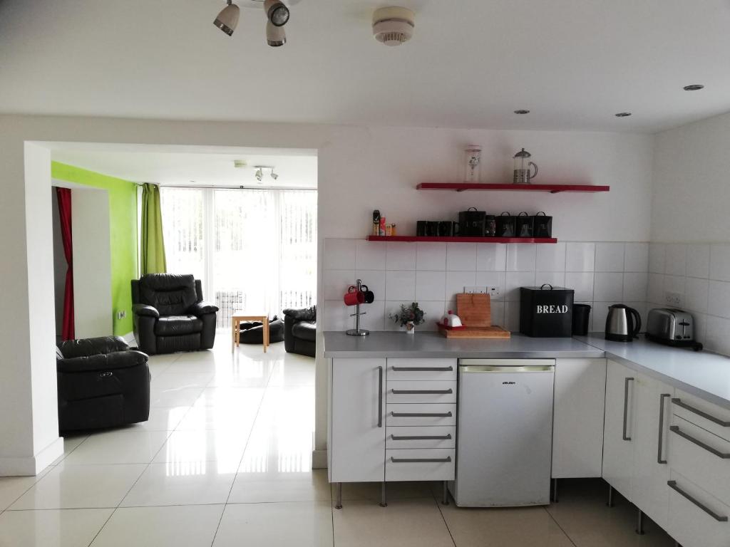 uma cozinha com electrodomésticos brancos e uma sala de estar em Cuilcagh House em Blacklion