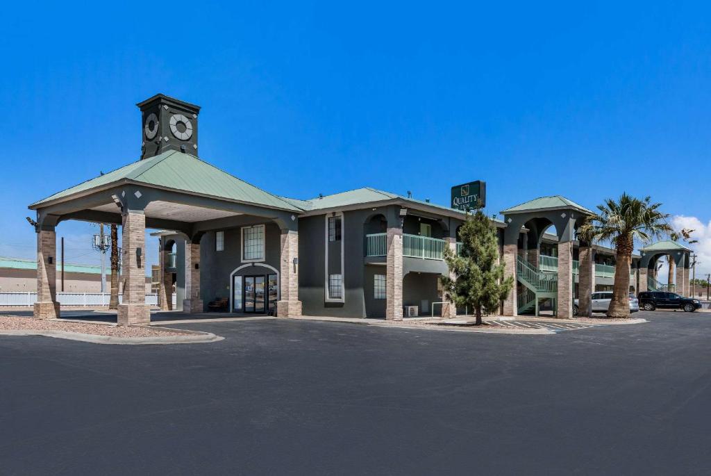 un edificio con una torre de reloj en un aparcamiento en Quality Inn, en Fort Stockton