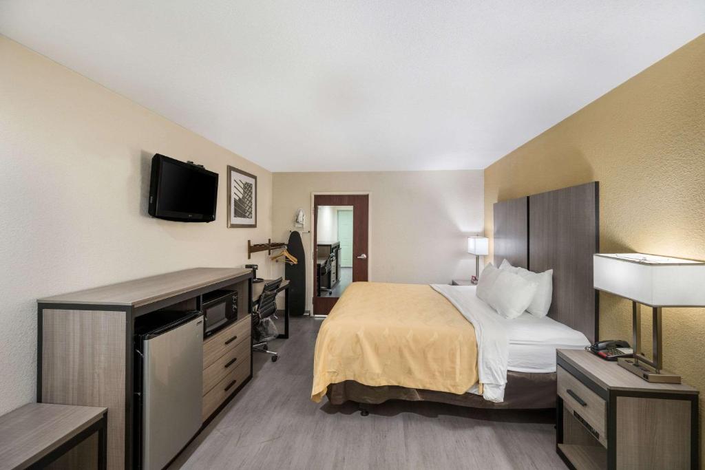 a hotel room with a bed and a flat screen tv at Quality Inn Fort Stockton in Fort Stockton