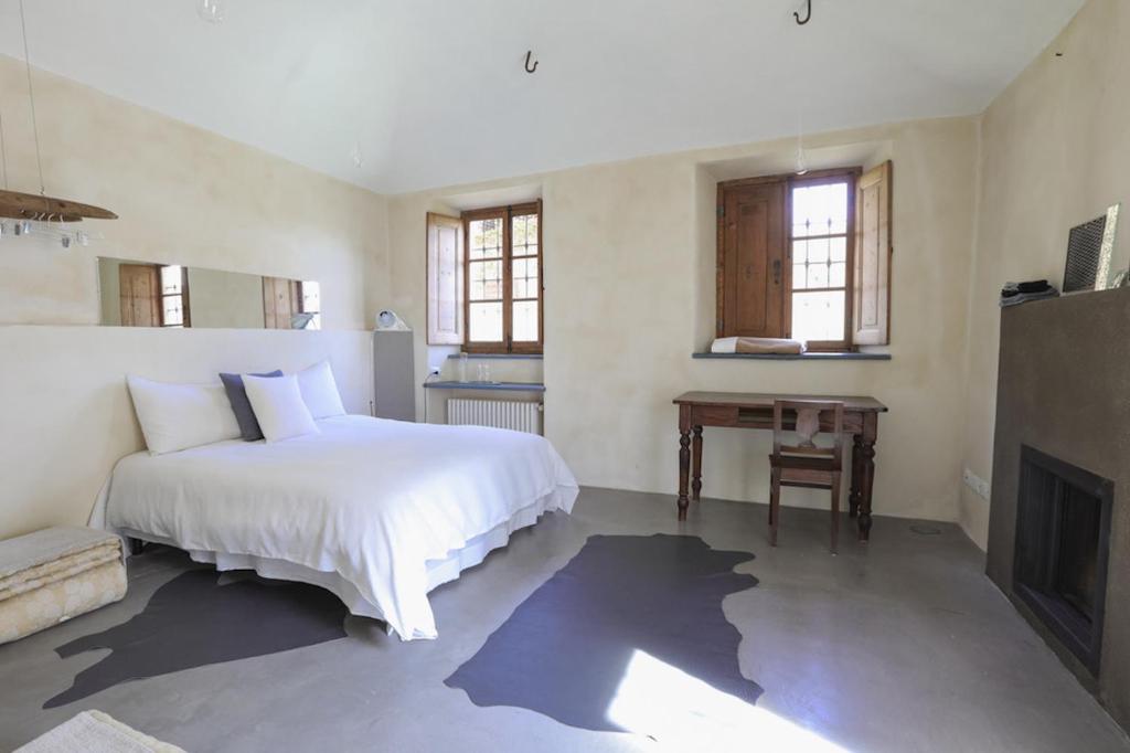 a bedroom with a white bed and a fireplace at Relax in Borgosesia